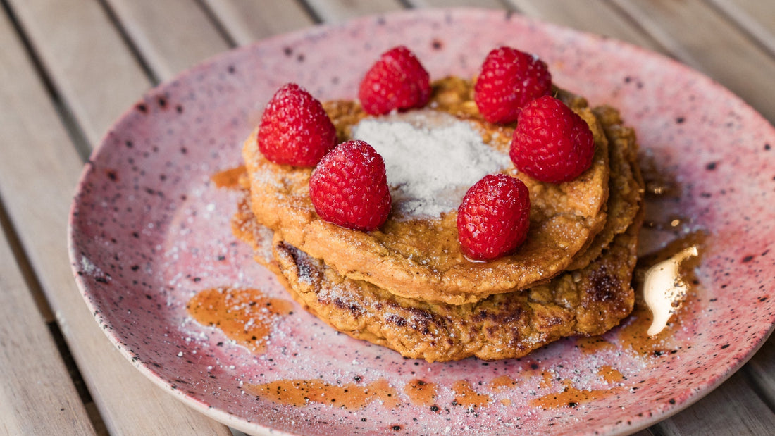 Veganské batátové lívance s pomerančem a malinami na keramickém talíři